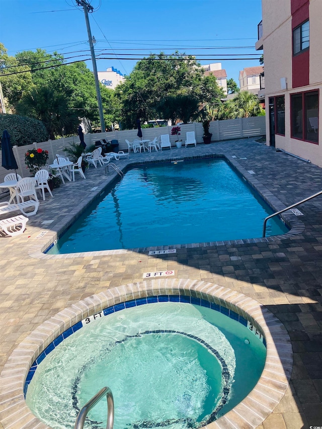 view of pool featuring a patio area and a hot tub