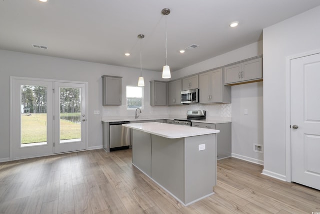 kitchen with gray cabinetry, visible vents, stainless steel appliances, and backsplash