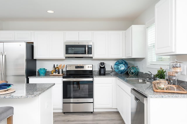 kitchen featuring sink, white cabinets, stainless steel appliances, and light hardwood / wood-style floors