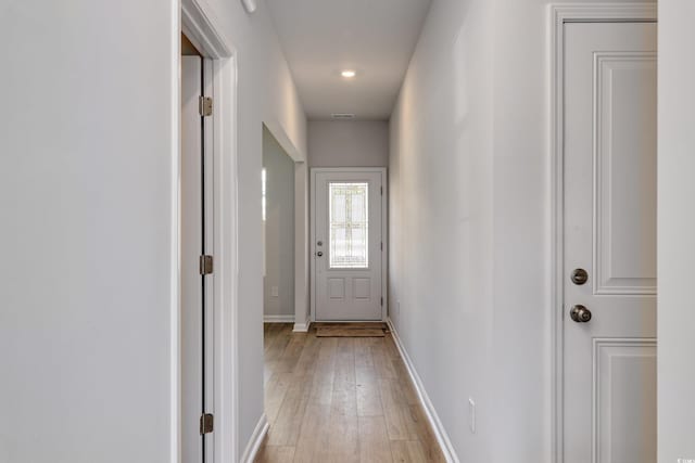 entryway with baseboards, visible vents, and light wood finished floors