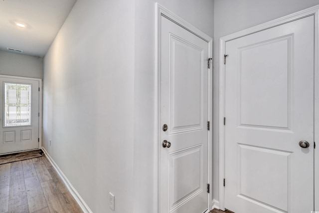 interior space with baseboards, light wood finished floors, and visible vents