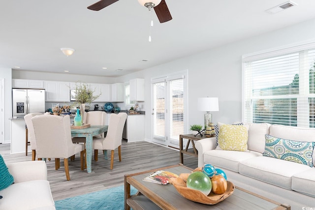 living room with light hardwood / wood-style flooring and ceiling fan