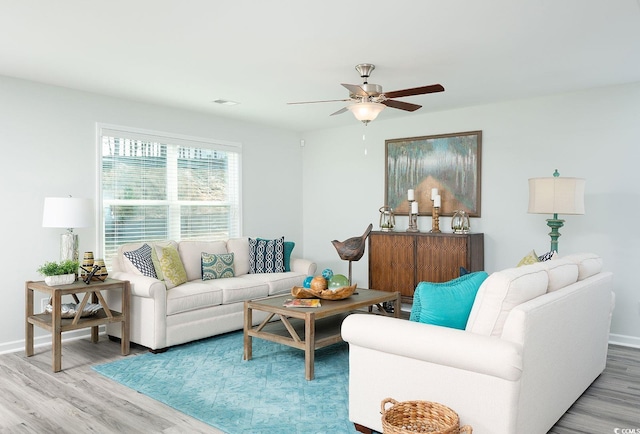 living room featuring wood-type flooring and ceiling fan