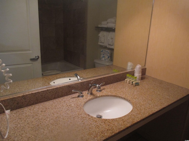 full bathroom with vanity, tiled shower / bath, and toilet