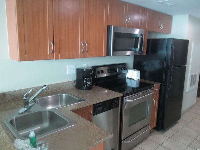 kitchen featuring sink, light tile patterned floors, and stainless steel appliances