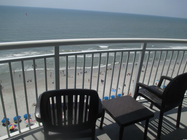 balcony featuring a water view and a view of the beach