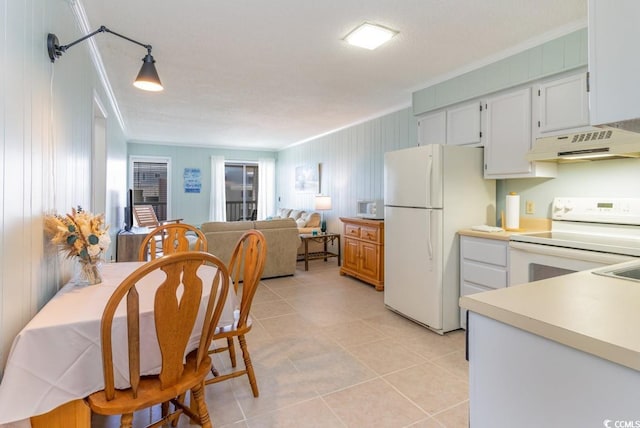 kitchen with crown molding, light countertops, custom range hood, light tile patterned floors, and white appliances