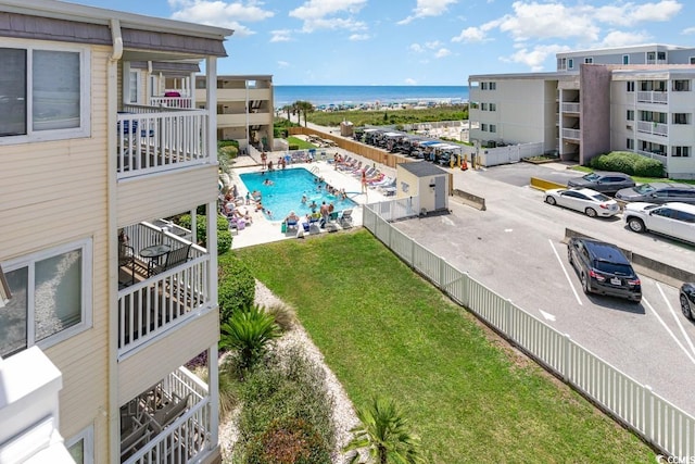 view of pool featuring a water view and a lawn