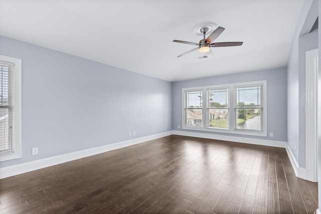 spare room with dark wood-style flooring, ceiling fan, lofted ceiling, and baseboards