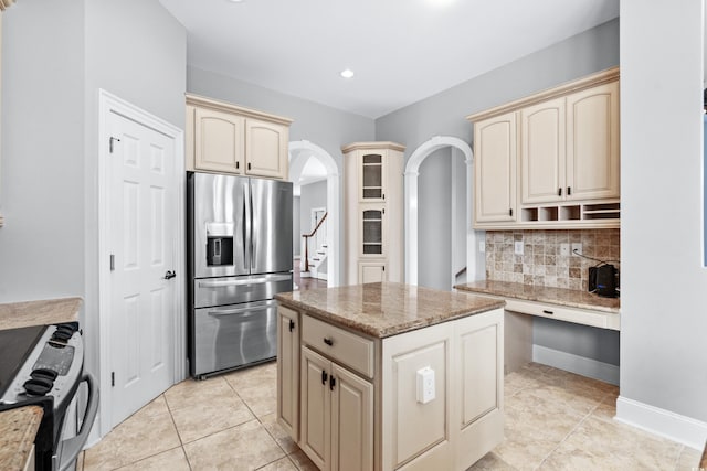 kitchen featuring a center island, light stone counters, stainless steel appliances, and tasteful backsplash