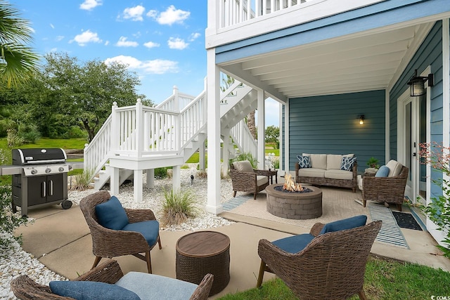 view of patio with grilling area, an outdoor living space with a fire pit, and stairs
