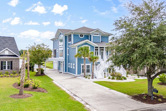 view of front of home featuring concrete driveway, stairs, a front lawn, and covered porch