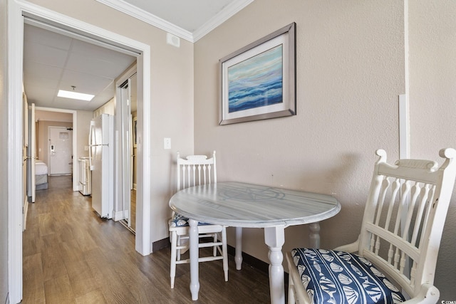 dining space featuring hardwood / wood-style flooring and crown molding