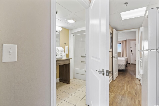 bathroom featuring shower / bathing tub combination, a drop ceiling, and hardwood / wood-style floors