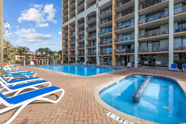 view of swimming pool with a hot tub