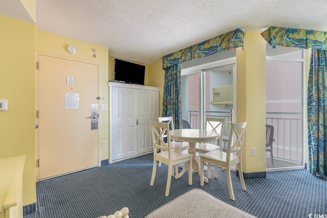 dining area with carpet and a textured ceiling