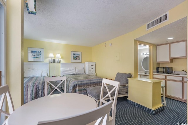 carpeted dining space featuring sink and a textured ceiling