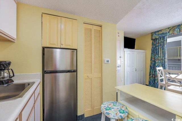 2701 S Ocean Blvd Unit 710, North Myrtle Beach, SC 29582 - kitchen featuring freestanding refrigerator, a textured ceiling, and light countertops