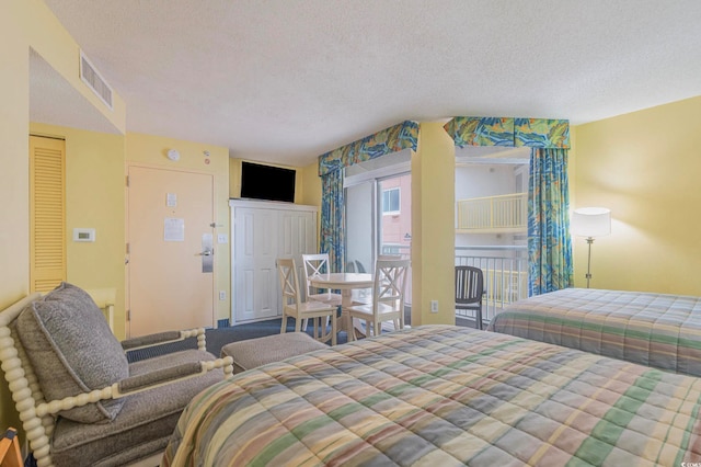 bedroom featuring access to exterior and a textured ceiling