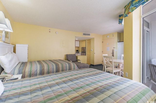 bedroom with carpet and stainless steel fridge