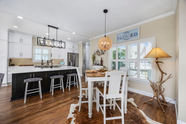 dining area with ornamental molding, dark hardwood / wood-style flooring, and a chandelier