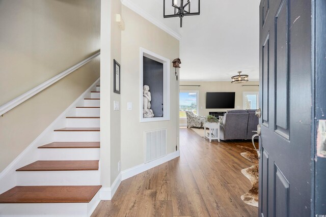 4524 Landing Rd, Little River, SC 29566 - entrance foyer with a chandelier, stairs, wood finished floors, and ornamental molding
