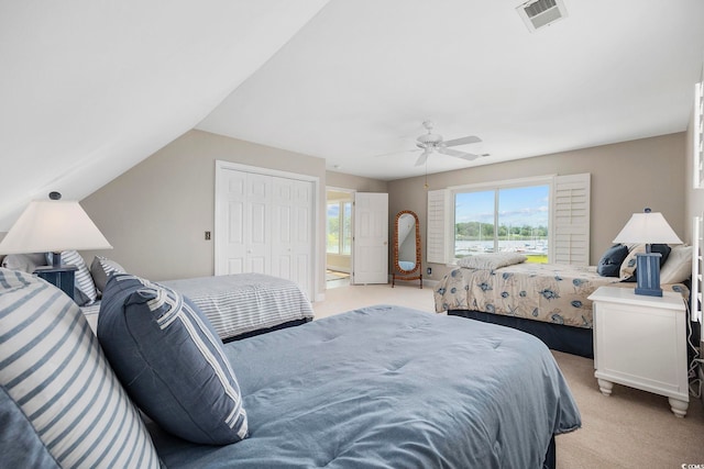 bedroom with lofted ceiling, light colored carpet, a closet, and ceiling fan