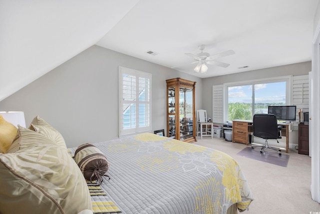 bedroom with vaulted ceiling, light colored carpet, and ceiling fan