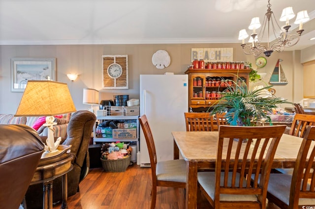 dining space featuring a notable chandelier, wood-type flooring, and crown molding