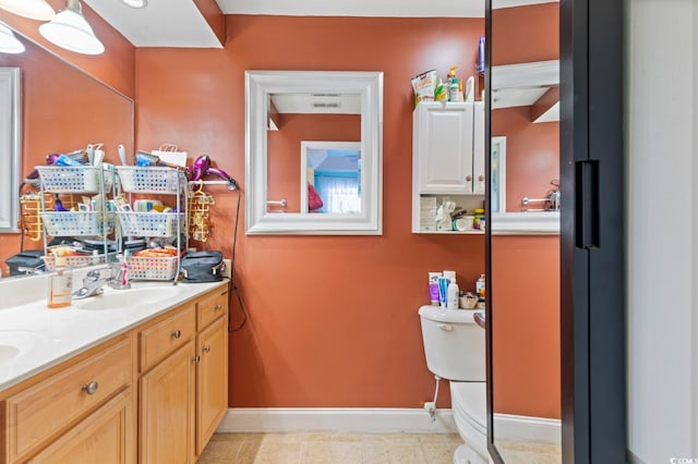 bathroom with vanity, tile patterned flooring, and toilet