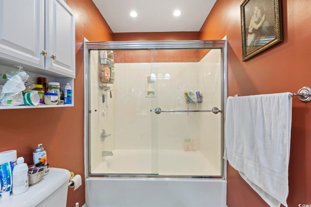 bathroom with shower / bath combination with glass door and toilet