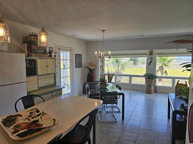 dining space featuring light tile patterned floors and a notable chandelier