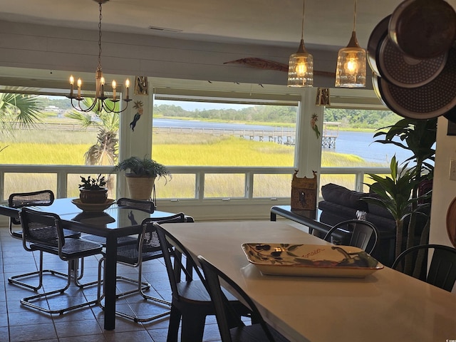 dining space with a water view and a notable chandelier