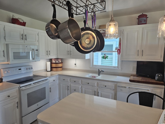 kitchen featuring sink, pendant lighting, white cabinets, and white appliances