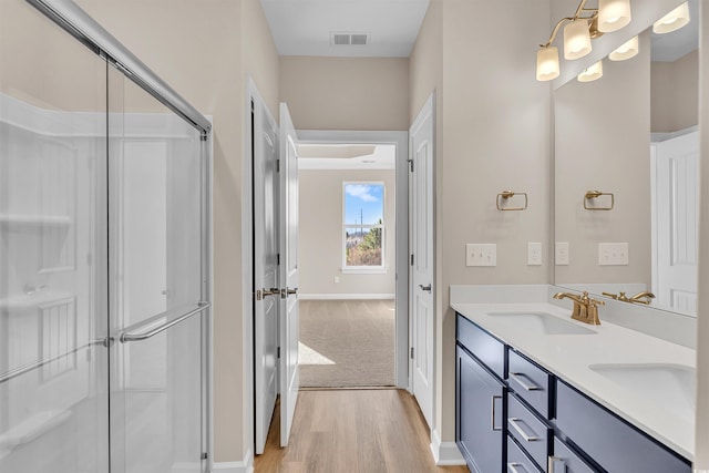 bathroom with a shower with door, vanity, and hardwood / wood-style flooring