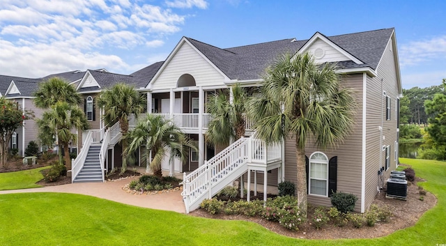 view of front of property featuring a porch, a front yard, and central AC