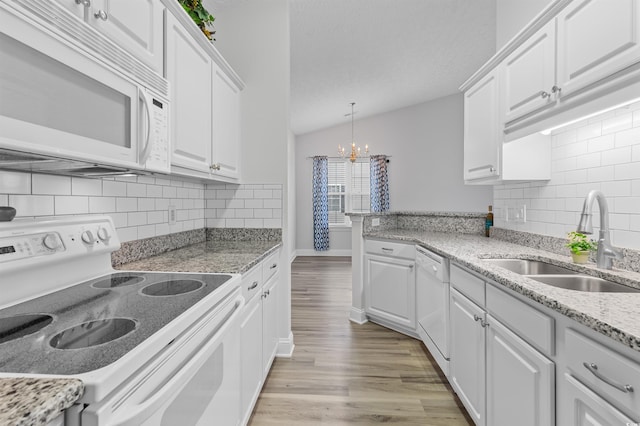 kitchen featuring white cabinetry, white appliances, sink, and vaulted ceiling