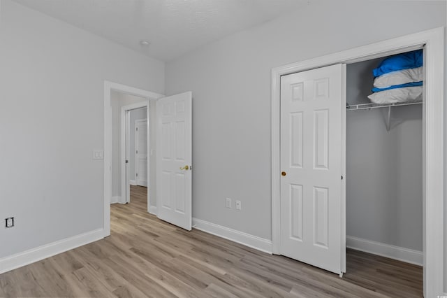 unfurnished bedroom with a closet and light hardwood / wood-style flooring