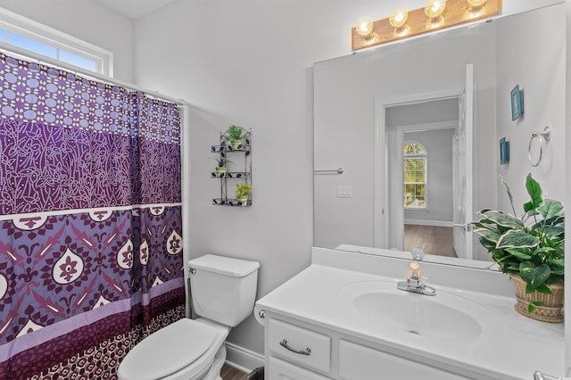 bathroom featuring plenty of natural light, vanity, and toilet