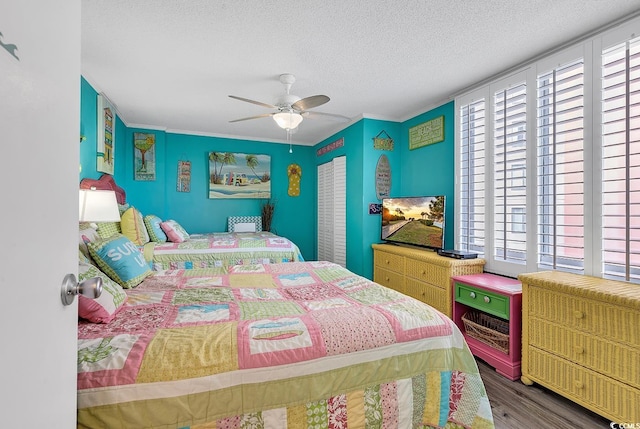 bedroom with dark hardwood / wood-style flooring, ornamental molding, a textured ceiling, and ceiling fan