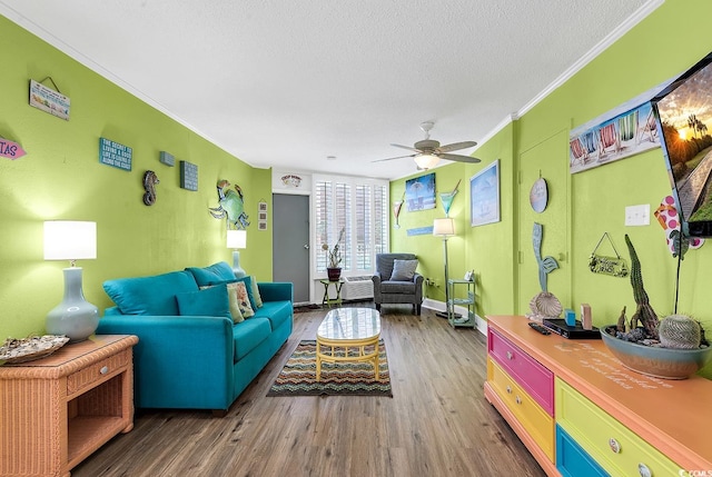 living room with hardwood / wood-style flooring, ceiling fan, a textured ceiling, and ornamental molding