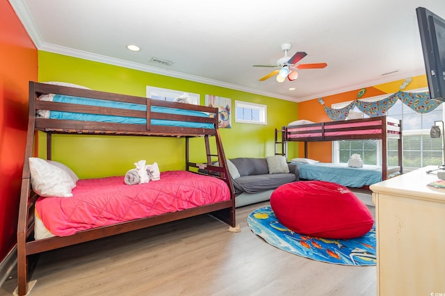 bedroom with hardwood / wood-style flooring, crown molding, and ceiling fan