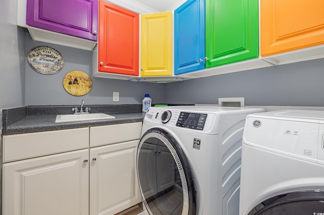 washroom featuring sink, cabinets, and washing machine and dryer