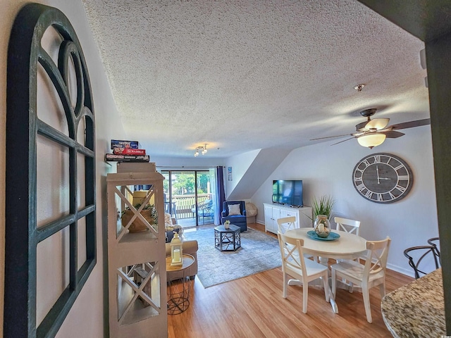 living room featuring ceiling fan, a textured ceiling, and light hardwood / wood-style flooring