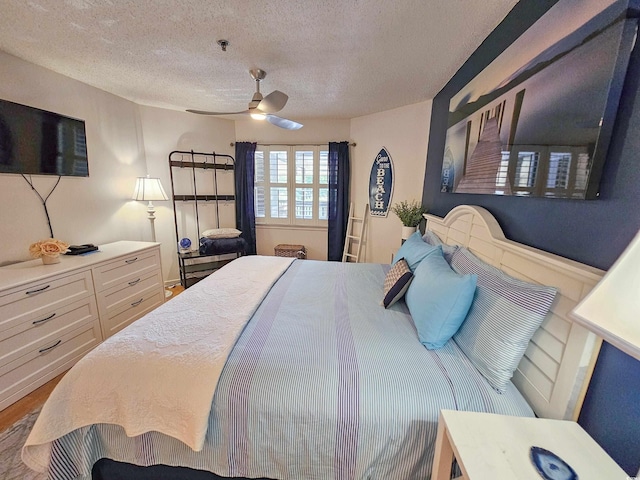 bedroom featuring a textured ceiling, hardwood / wood-style floors, and ceiling fan