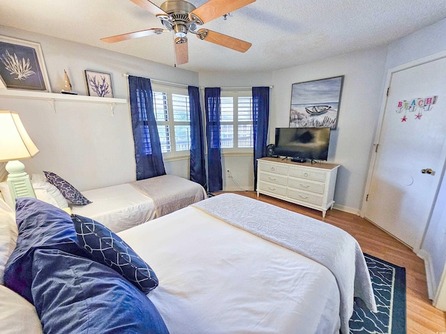 bedroom featuring a textured ceiling, ceiling fan, and light hardwood / wood-style flooring