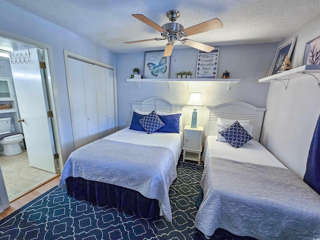 bedroom featuring a textured ceiling, wood-type flooring, ceiling fan, and a closet