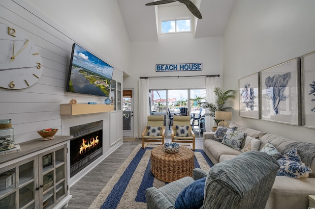 living room with wooden walls, dark hardwood / wood-style flooring, and high vaulted ceiling