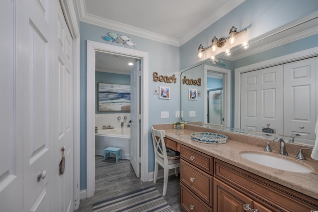 bathroom featuring tiled tub, vanity, wood-type flooring, and ornamental molding