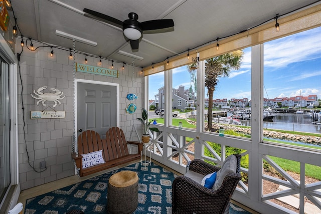 sunroom / solarium with a water view and ceiling fan